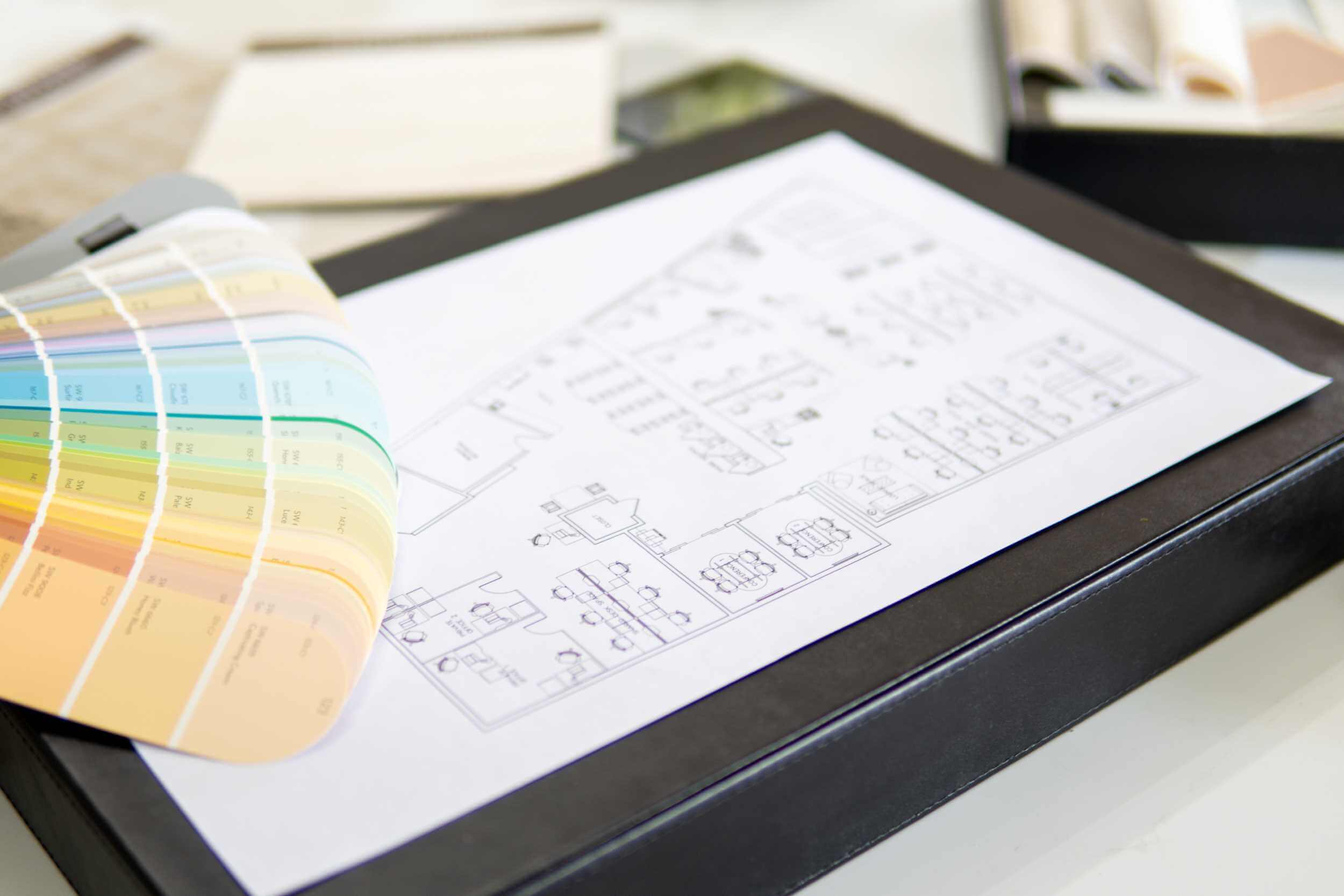 Interior designer reviewing floor plan and material selections to avoid renovation mistakes
