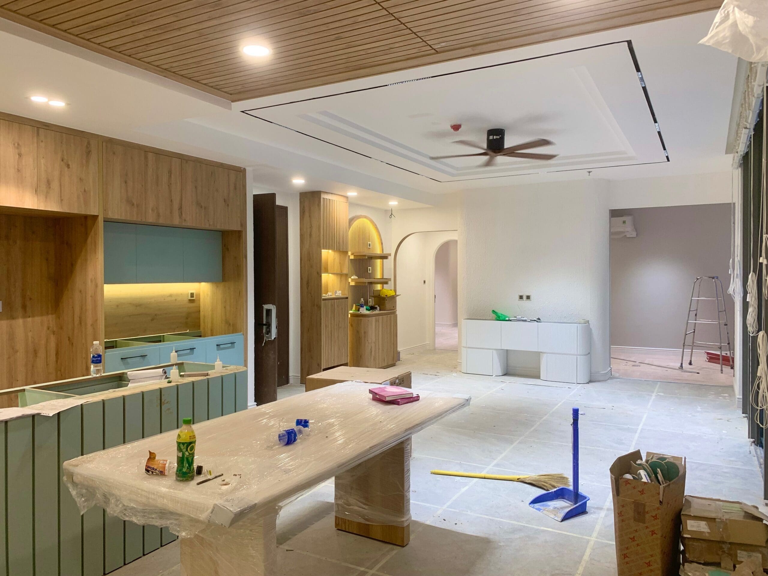 Open-concept home undergoing renovation before move-in, featuring unfinished custom cabinetry, new ceiling details, and interior construction in a Vancouver home.