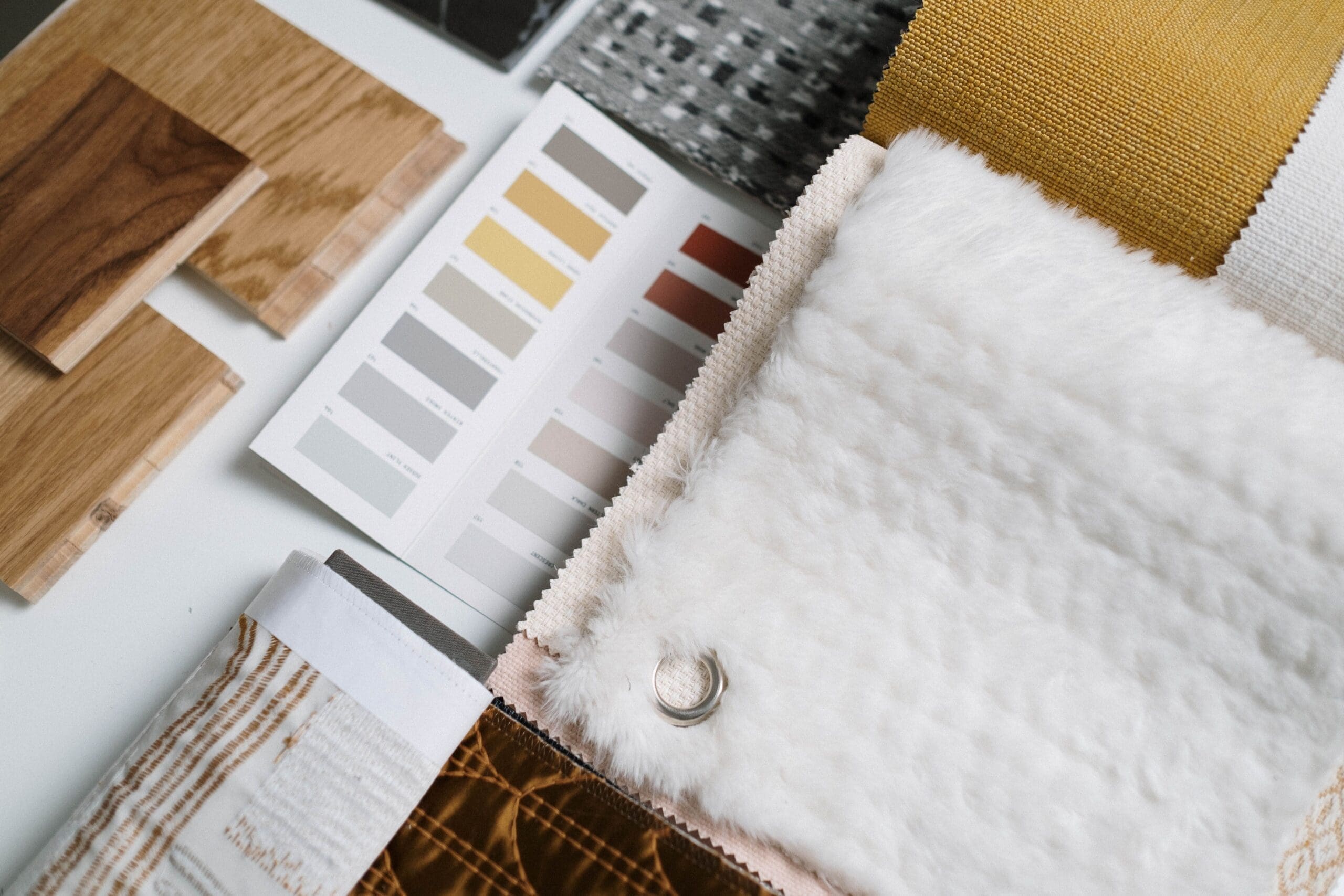 Interior designer selecting flooring, tile, countertop, paint, and material samples for a home renovation.
