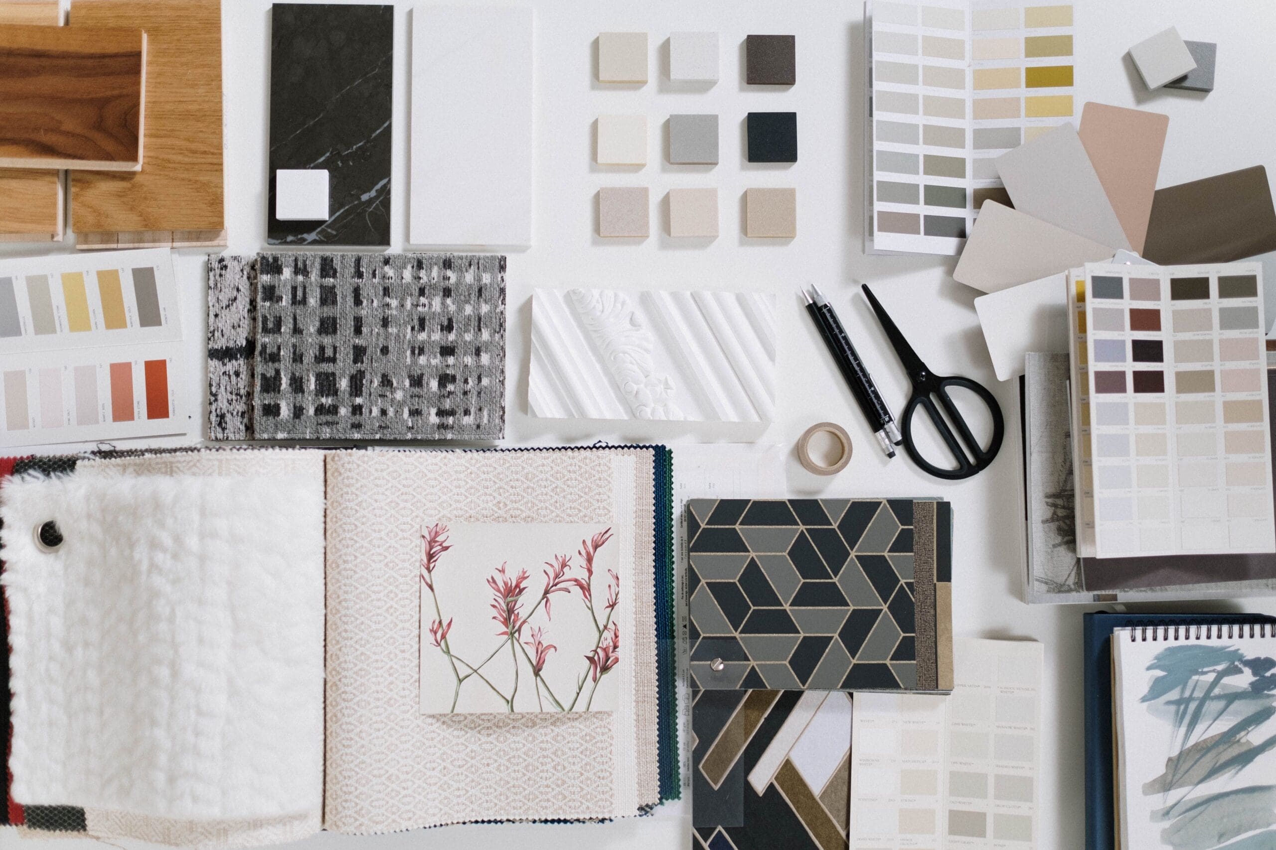 Interior design mood board with flooring, tile, paint colours, fabric, and material samples for home renovation planning.