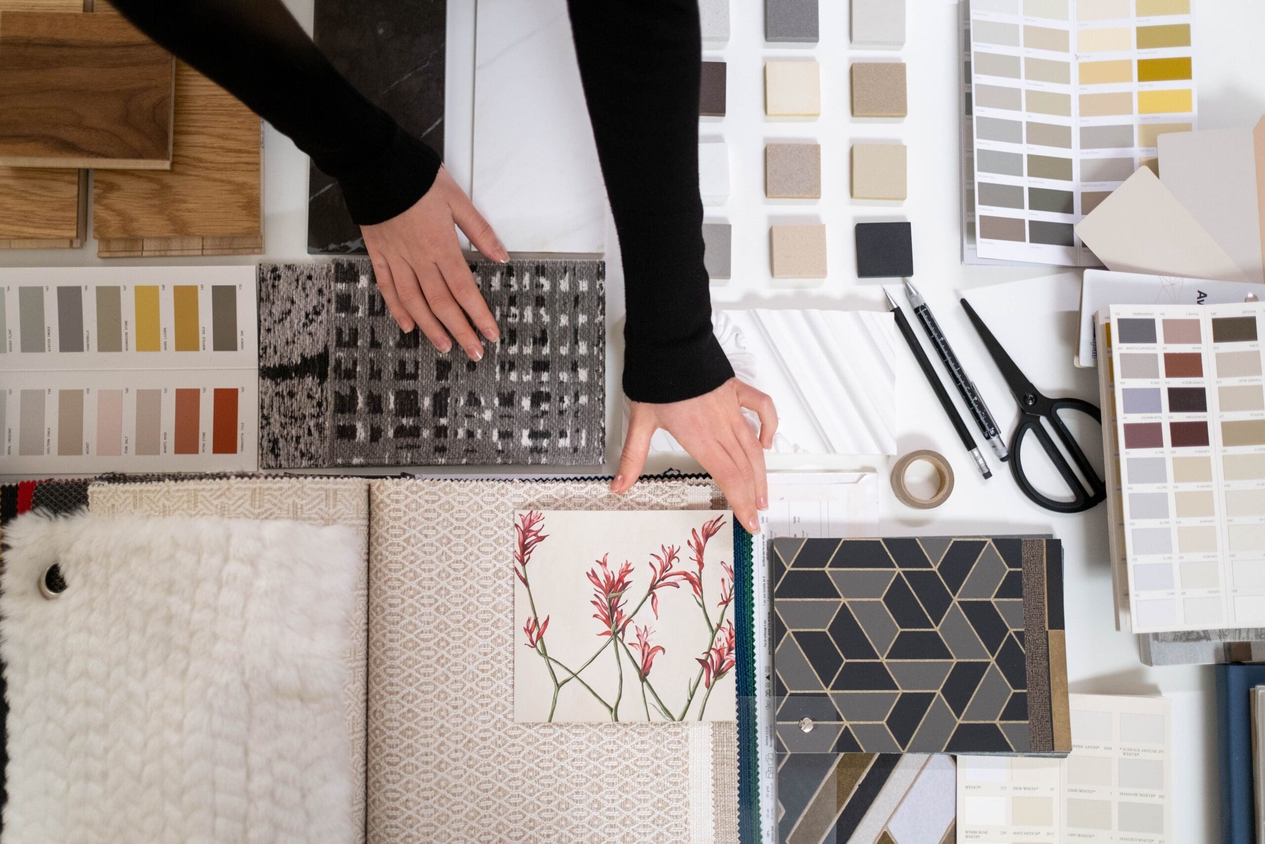 Interior designer selecting fabric, tile, wood, and paint samples for a full-service home renovation project in Vancouver.